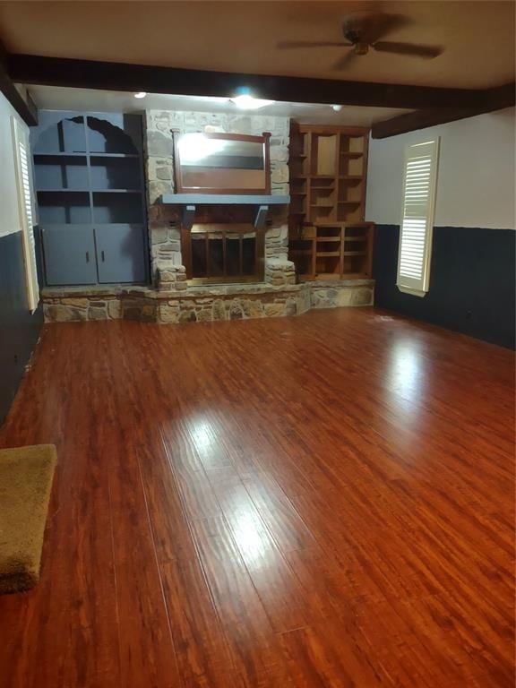 unfurnished living room with beamed ceiling, hardwood / wood-style floors, and a fireplace