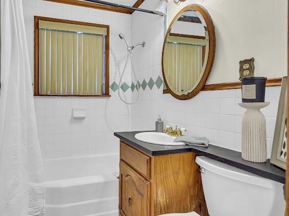 full bathroom with tasteful backsplash, shower / bath combination with curtain, toilet, vanity, and tile walls