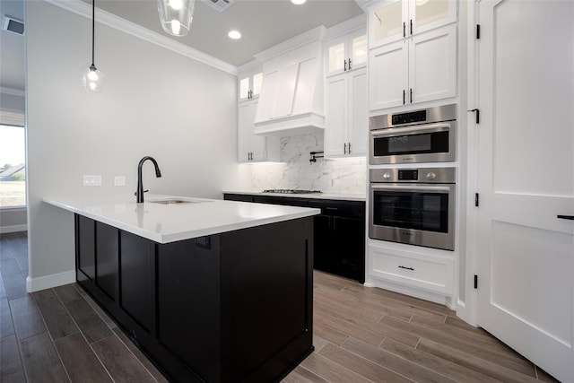 kitchen featuring white cabinetry, stainless steel appliances, and wood-type flooring