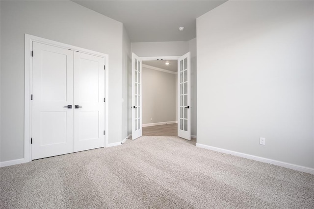 unfurnished bedroom featuring a closet, french doors, and carpet