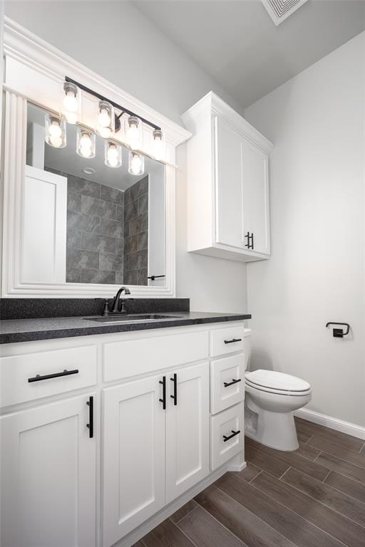 bathroom featuring vanity, toilet, and wood-type flooring