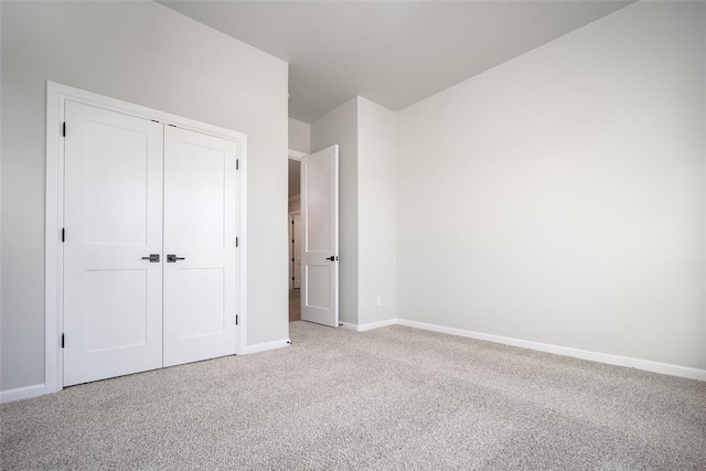 unfurnished bedroom featuring light carpet and a closet