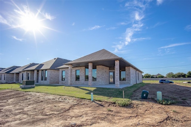 view of front of property with a patio area, cooling unit, and a front lawn