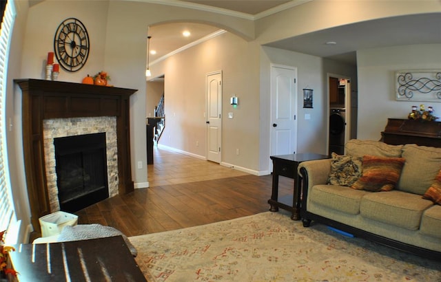 living room with dark hardwood / wood-style floors, a fireplace, washer / dryer, and crown molding