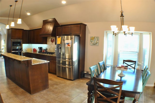 kitchen featuring premium range hood, pendant lighting, stainless steel appliances, and lofted ceiling