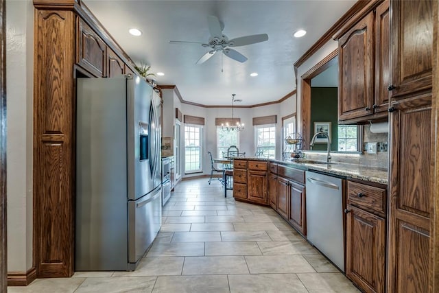 kitchen with crown molding, ceiling fan with notable chandelier, recessed lighting, a sink, and appliances with stainless steel finishes
