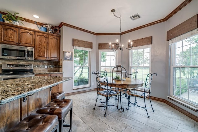 dining space featuring baseboards, a chandelier, plenty of natural light, and visible vents