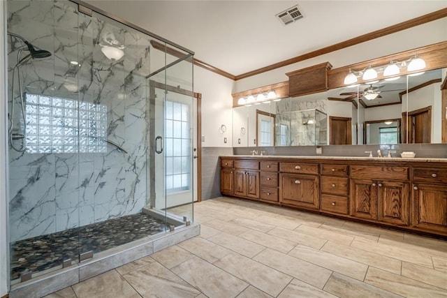 full bathroom featuring plenty of natural light, a marble finish shower, ornamental molding, and visible vents