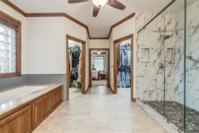 bathroom featuring a garden tub, a ceiling fan, a marble finish shower, and a walk in closet