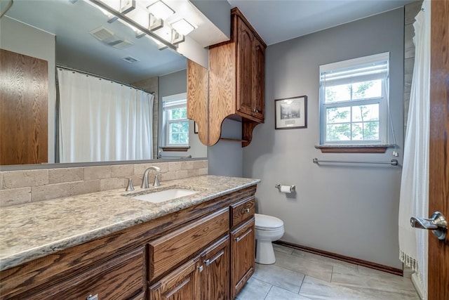 bathroom featuring visible vents, baseboards, toilet, and vanity