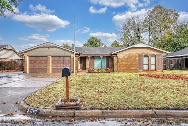 ranch-style home with an attached garage, brick siding, driveway, a front lawn, and a chimney