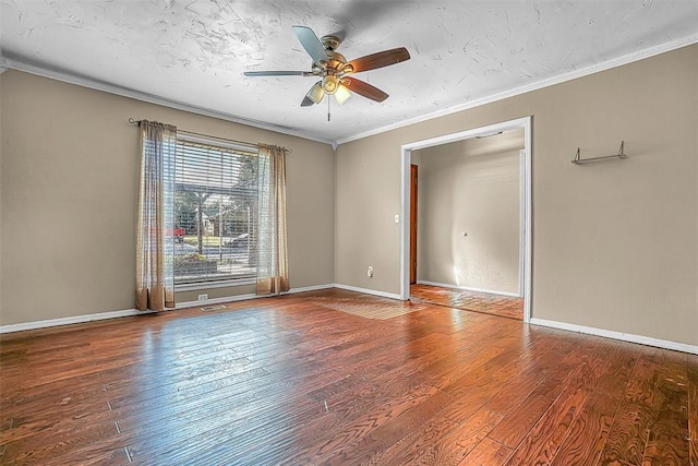 spare room featuring baseboards, ornamental molding, and wood finished floors