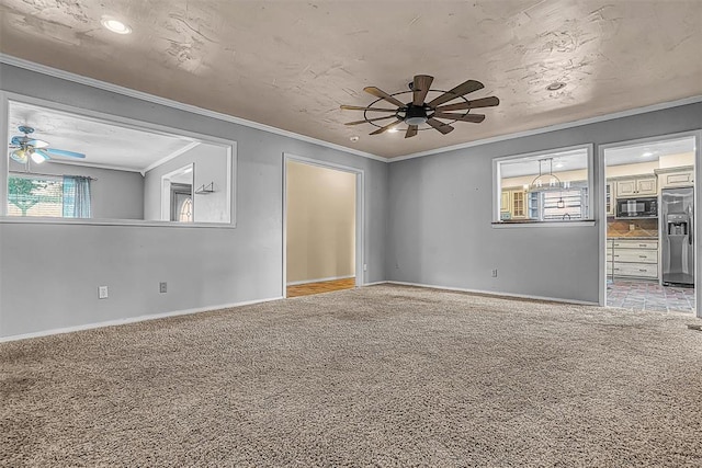 carpeted empty room featuring baseboards, ornamental molding, and a ceiling fan