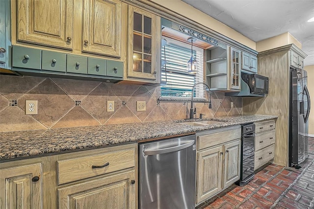 kitchen with dark stone counters, a sink, refrigerator with ice dispenser, dishwasher, and glass insert cabinets