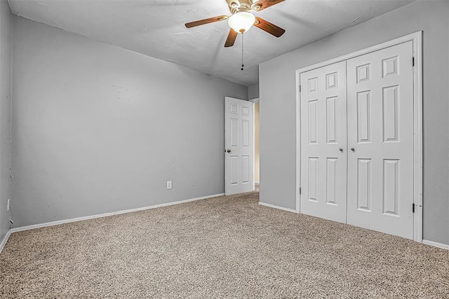 unfurnished bedroom with a ceiling fan, a closet, carpet flooring, and baseboards