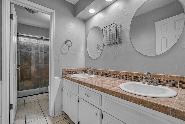 bathroom featuring double vanity, toilet, a sink, and tile patterned floors