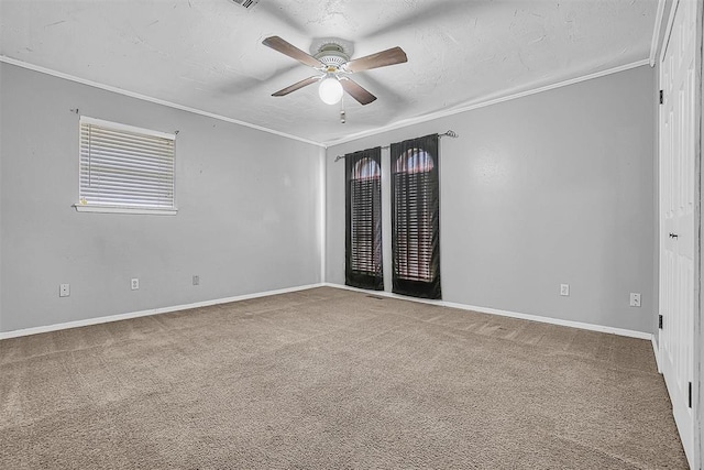 spare room with baseboards, ceiling fan, carpet, a textured ceiling, and crown molding