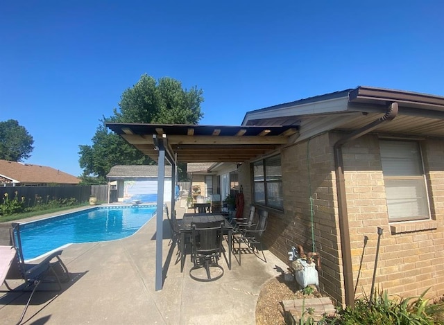 view of swimming pool with a patio area, fence, a fenced in pool, and an outdoor structure