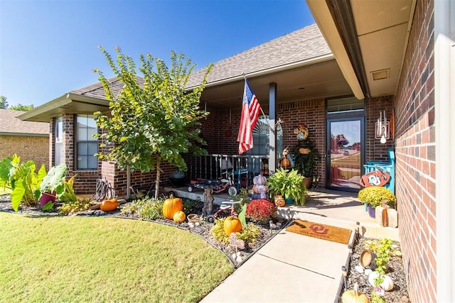 doorway to property featuring a yard and a porch