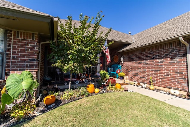 view of exterior entry featuring a yard