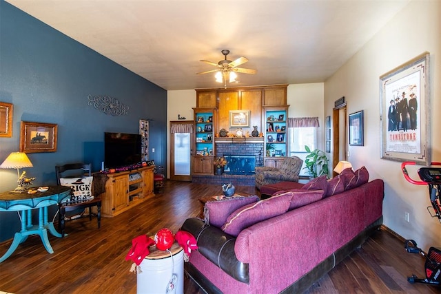 living room featuring ceiling fan, dark hardwood / wood-style floors, and a brick fireplace