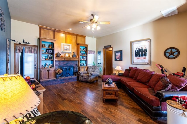 living room featuring a wealth of natural light, dark hardwood / wood-style flooring, ceiling fan, and a brick fireplace