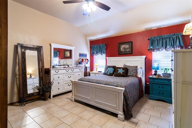 bedroom with ceiling fan, light tile patterned floors, and vaulted ceiling