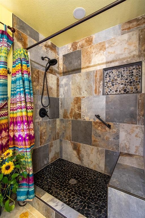 bathroom featuring a shower with curtain and a textured ceiling