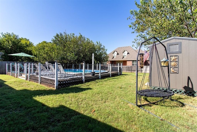 view of yard with a fenced in pool and a storage shed