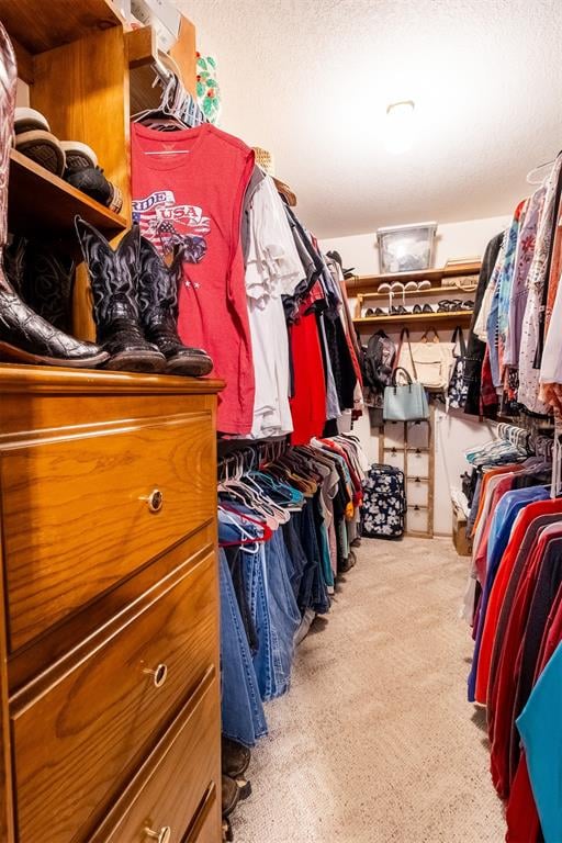 walk in closet featuring light colored carpet