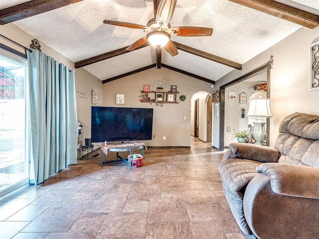 living room featuring vaulted ceiling with beams, a textured ceiling, and ceiling fan