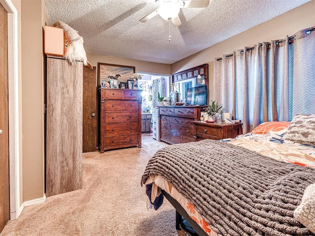 bedroom featuring ceiling fan, a textured ceiling, and light carpet