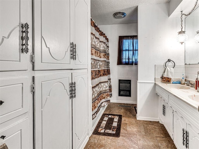 bathroom with vanity, a textured ceiling, and heating unit