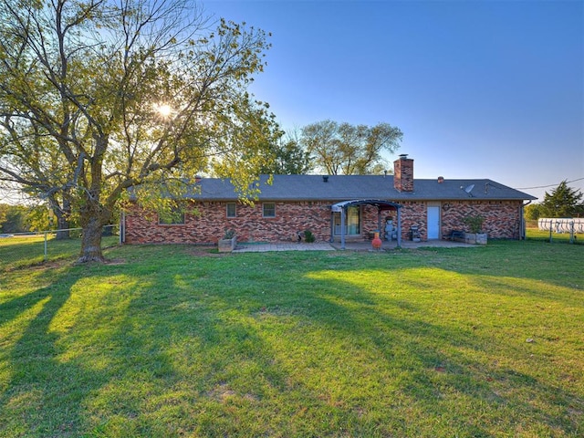 rear view of house with a yard and a patio area