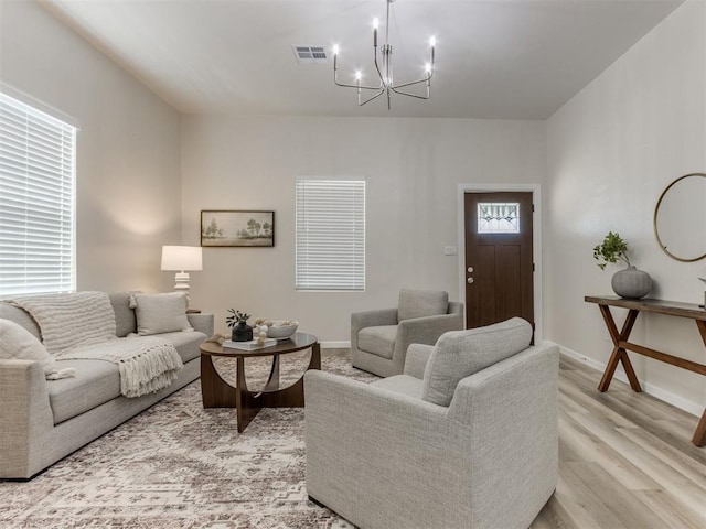 living room with a chandelier and light hardwood / wood-style floors