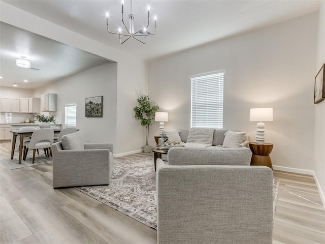 living room with an inviting chandelier and light wood-type flooring