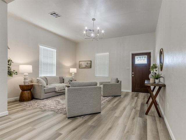 living room featuring light hardwood / wood-style floors and a notable chandelier