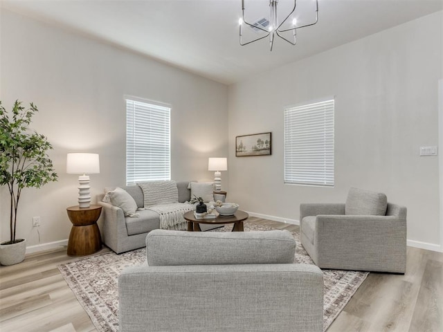 living room featuring light hardwood / wood-style floors and an inviting chandelier