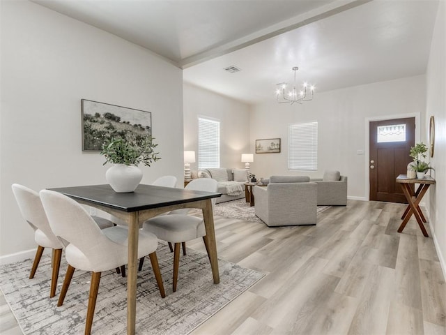 dining room featuring light wood-type flooring and a notable chandelier