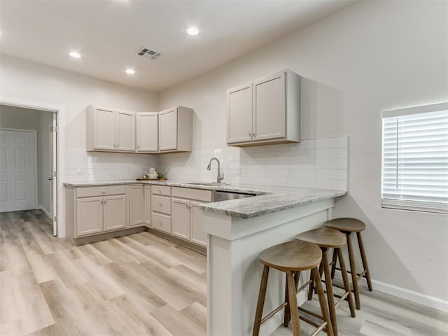 kitchen featuring light wood-type flooring, white cabinetry, and sink