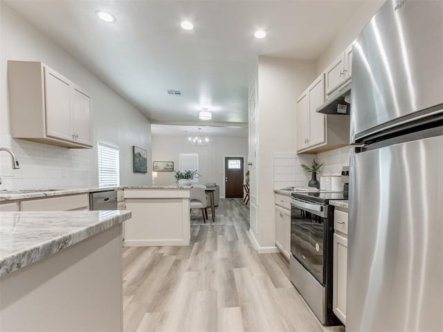 kitchen with sink, decorative backsplash, light wood-type flooring, white cabinetry, and stainless steel appliances