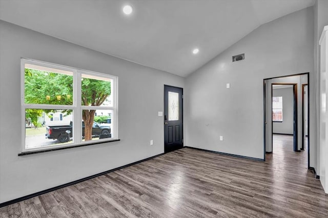 interior space featuring hardwood / wood-style flooring, vaulted ceiling, and a healthy amount of sunlight