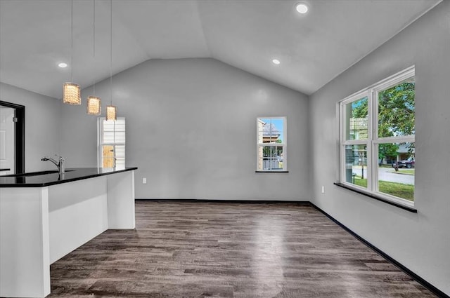 unfurnished living room with a chandelier, dark hardwood / wood-style floors, and lofted ceiling