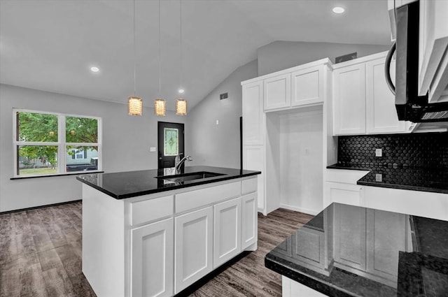 kitchen featuring a center island with sink, dark hardwood / wood-style flooring, pendant lighting, and white cabinets