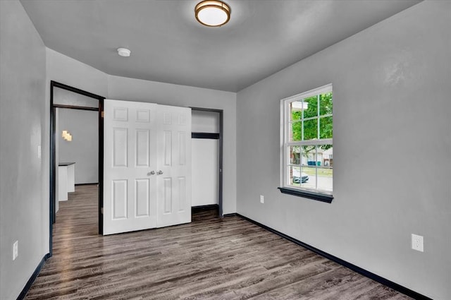 unfurnished bedroom with hardwood / wood-style flooring and a closet