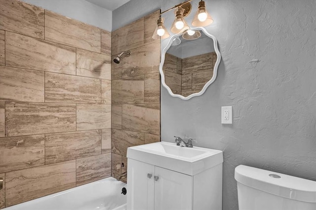 full bathroom with vanity, tiled shower / bath combo, and toilet