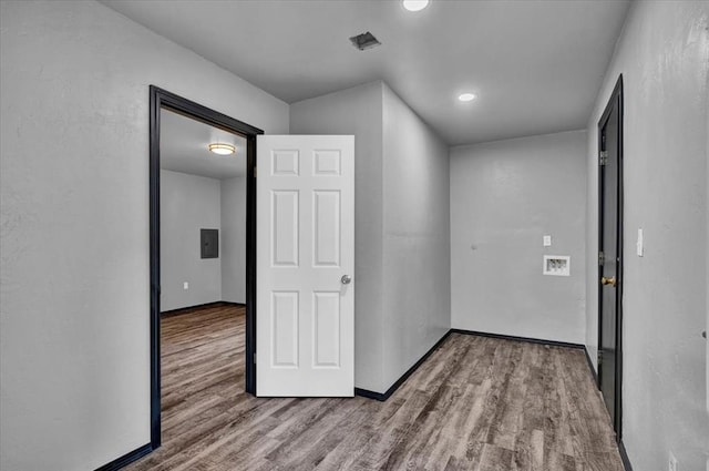 hall featuring electric panel and light hardwood / wood-style flooring