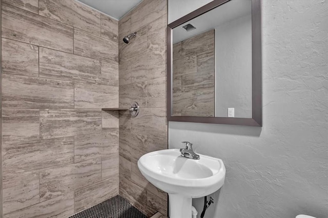 bathroom featuring sink and tiled shower