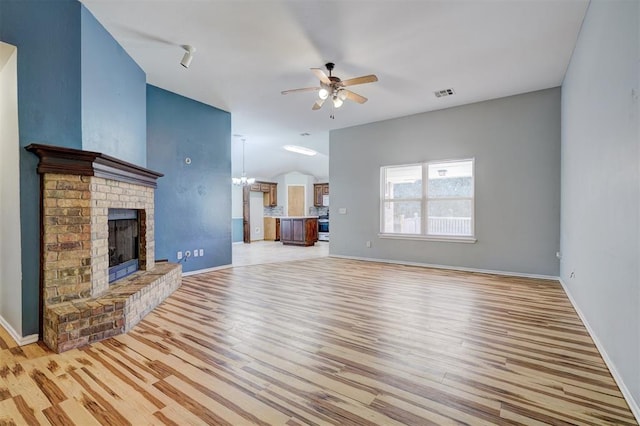 unfurnished living room featuring a fireplace, light hardwood / wood-style floors, and ceiling fan with notable chandelier