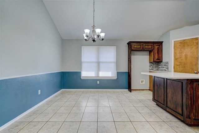 kitchen featuring a notable chandelier, light tile patterned floors, hanging light fixtures, and vaulted ceiling